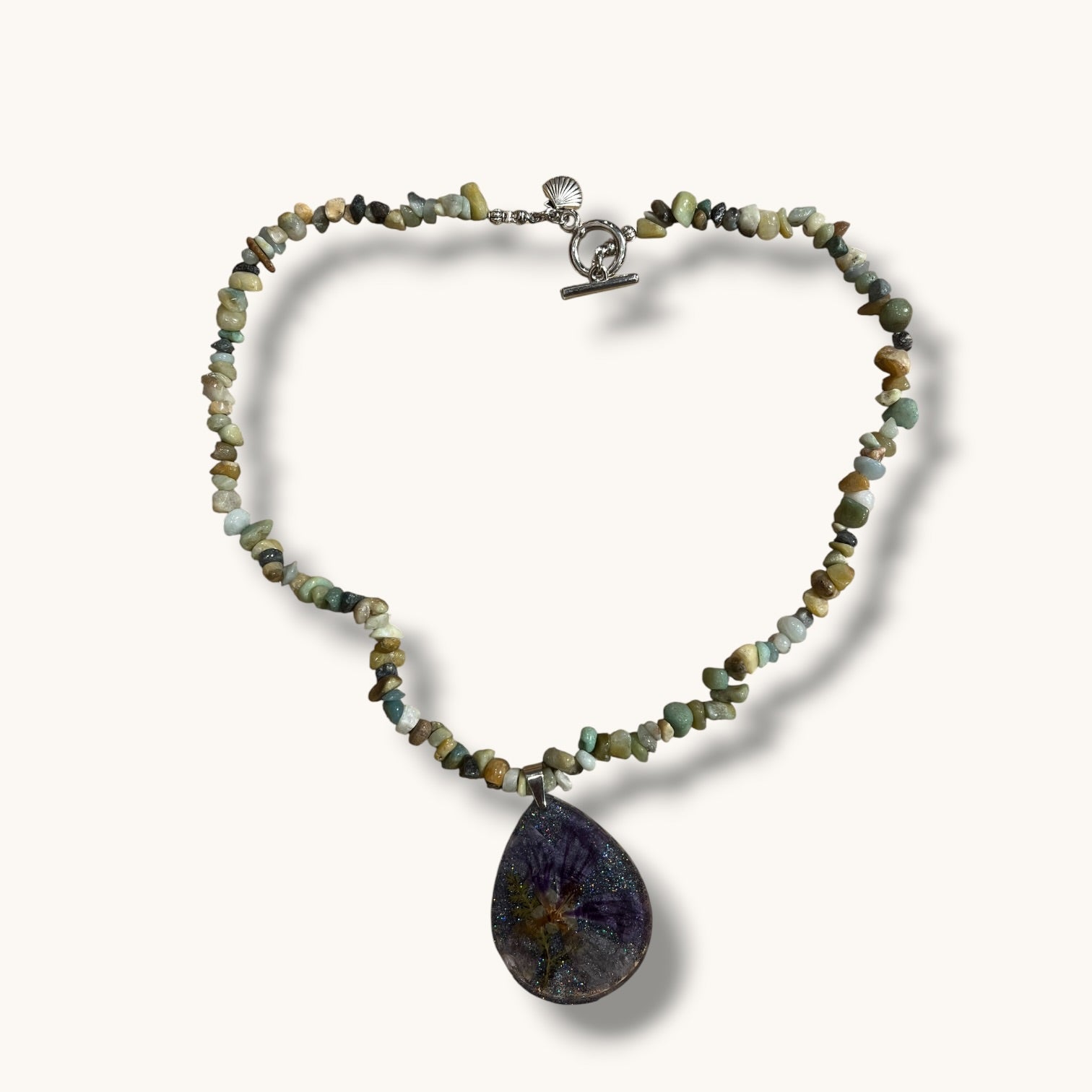 Teardrop resin pendant with a real white daisy flower on a stone beaded choker necklace with a silver toggle clasp