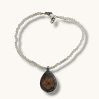 Teardrop resin pendant with a real white daisy flower on a white beaded choker necklace with a silver toggle clasp